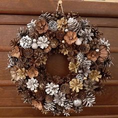 a wreath is hanging on the door with pine cones and other holiday decorations around it