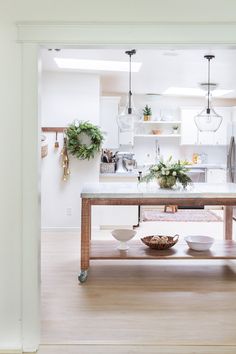 a kitchen with a table and some plants on the counter top in front of it