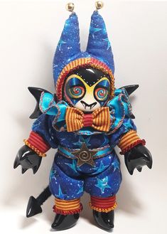 a blue and orange figurine with stars on it's face, wearing a costume