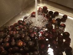 grapes are being washed in a sink with water