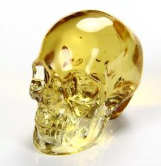 a yellow crystal skull sitting on top of a white table