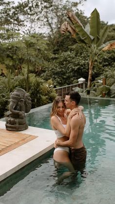 a man and woman are hugging in the pool