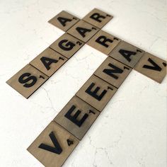 the cross is made out of wooden blocks with numbers on them and letters below it