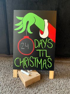 a sign with the words 24 days til christmas written on it next to a block of wood