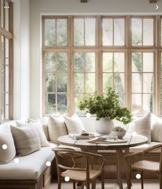 a living room filled with furniture next to a window covered in lots of white pillows