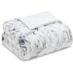 the white and grey fur blanket is folded on top of each other