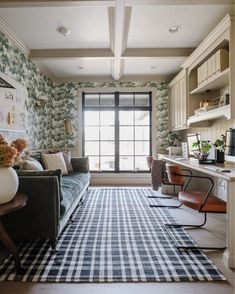 a living room filled with furniture next to a window and a rug on the floor