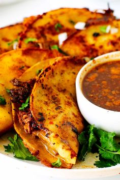 some food is on a plate with sauce and breads next to it for garnishes