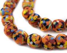 a multicolored bead necklace is displayed on a white surface with an orange, yellow, and blue design