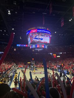 a basketball game is being played in an arena with people sitting on the sidelines