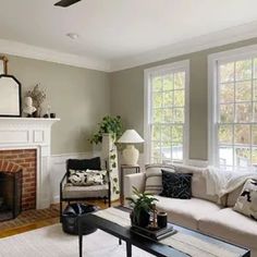 a living room filled with furniture and a fire place in front of a large window