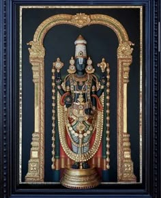 an ornately decorated statue in gold and black frame with blue border around the edges