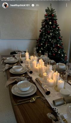 a table set for christmas with candles and plates