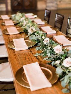 a long table with plates and napkins on it, set for dinner or reception