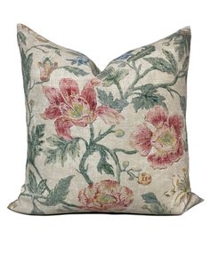 a floral pillow with pink and green flowers on the front, sitting on a white background