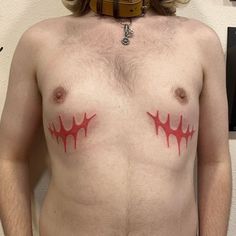 a shirtless man with red paint on his chest and neck, wearing a harness