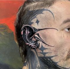 a man with tattoos on his face and neck