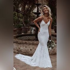 a woman in a white wedding dress posing for the camera with her hands on her hips