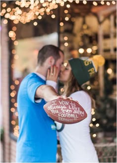 a man and woman kissing in front of christmas lights