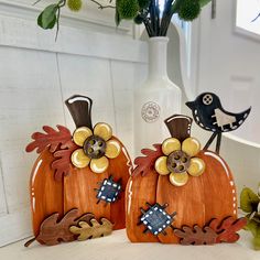 two wooden pumpkins with decorative decorations on them