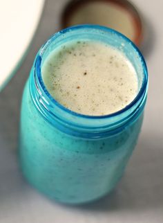 a blue mason jar filled with liquid sitting on top of a table