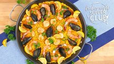 a paella with shrimp, mussels and lemon slices