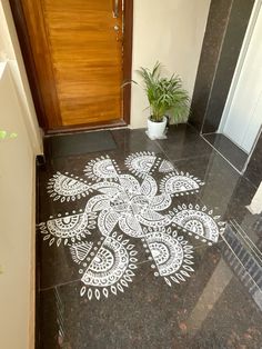 a white and black patterned floor in front of a door with a potted plant