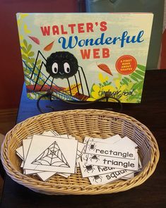 a basket with some cards in it and a book on the table next to it