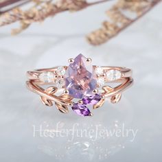 a ring with an amethorate and white diamonds on it, sitting next to dried flowers