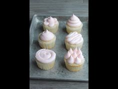 cupcakes with pink frosting sitting on a tray