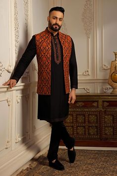 Black and rust orange sleeveless open bundi in pashmina blend base with all over kashmiri damask embroidery. Paired with long sleeves placket embroidered kurta and a churidar.
Components: 3
Pattern: Embroidery
Type Of Work: Damask
Neckline: Band Collar
Sleeve Type: Bundi: Sleeveless, Kurta: Long
Fabric: Pashmina Blend
Color: Black
Occasion: Sangeet - Aza Fashions Luxury Nehru Jacket With Naqshi For Festive Occasions, Luxury Naqshi Nehru Jacket For Festive Occasions, Luxury Red Nehru Jacket For Formal Occasions, Luxury Red Nehru Jacket For Winter, Black Pashmina, Sleeveless Kurta, Kurta Set For Men, Nehru Jackets, Pattern Embroidery