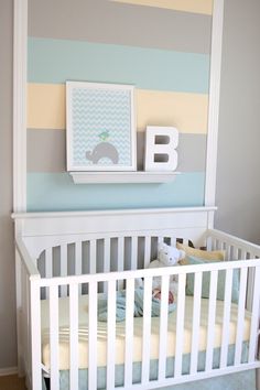 a baby's room with a striped wall and white crib