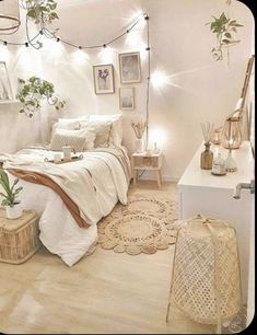 a white bedroom with plants and pictures on the wall