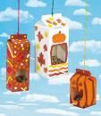 three boxes are hanging from strings in the sky with autumn leaves and pumpkins on them