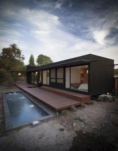 a small house with a pool in the middle of it and a deck next to it