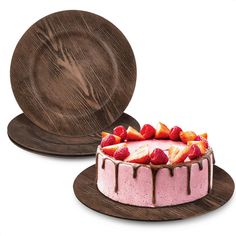 a cake with strawberries on top is next to a wooden plate