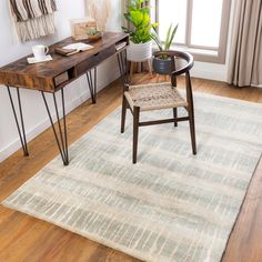 a room with a table, chair and rug in it