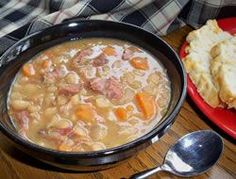 a bowl of soup and some bread on a table