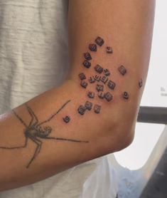 a person with a tattoo on their arm has cubes in the shape of a spider