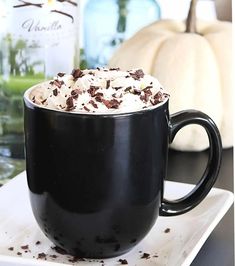 a black mug filled with whipped cream and chocolate chips