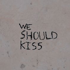 graffiti written on the side of a wall that says we should kiss