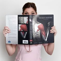 a woman holding up a book in front of her face