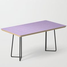 a purple table sitting on top of a white floor next to a black metal frame