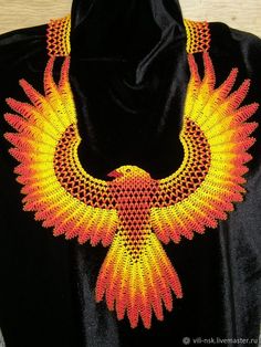 an elaborate necklace is displayed on a black mannequin with red and yellow beads