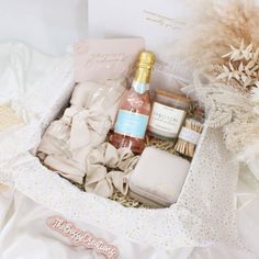 a gift box filled with personal care items on top of a white sheet covered bed