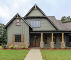 a gray house with brown shutters and green grass