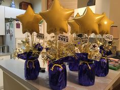 purple vases filled with gold stars and streamers for new year's eve