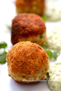 small crab cakes are lined up on a white plate