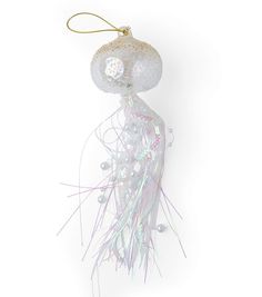 a white ornament hanging from a hook on a string with beads and streamers