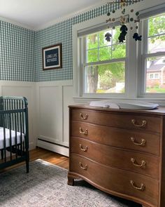 a baby's crib and dresser in a room with blue checkered walls